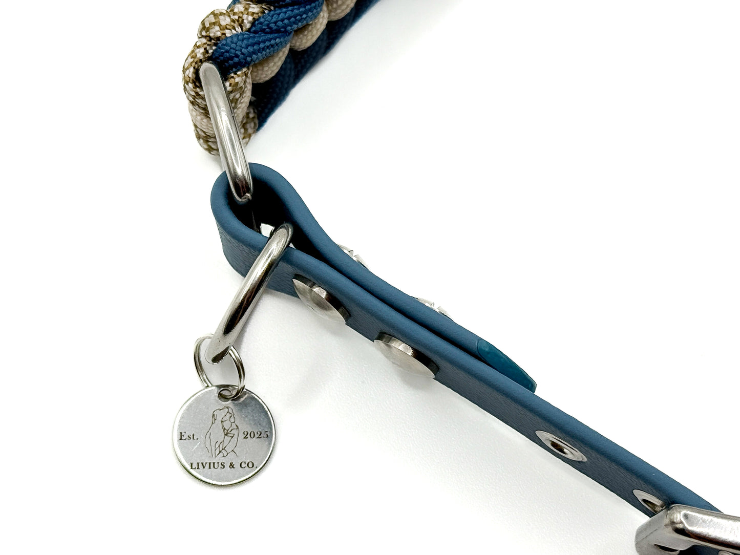 Handgefertigtes Halsband aus Paracord und Biothaneschnalle geflochten in cream und petrolblau. Mit Biothaneschnalle und silbernen Beschlägen. Mit Logoanhänger.