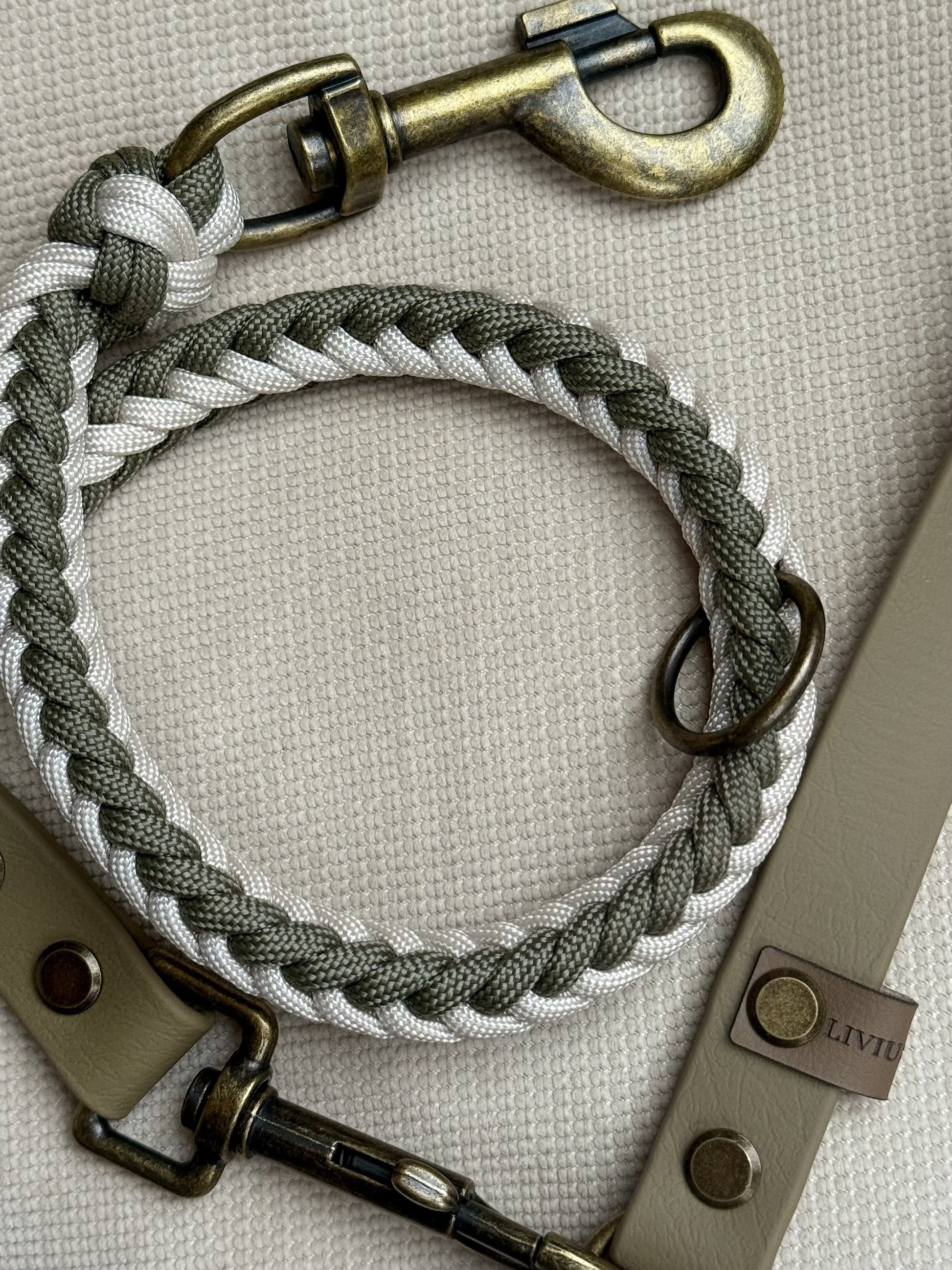 Handgefertigte Hundeleine aus Paracord und Biothane in Creamund Olivtönen mit antik-messingfarbenen Karabinern.